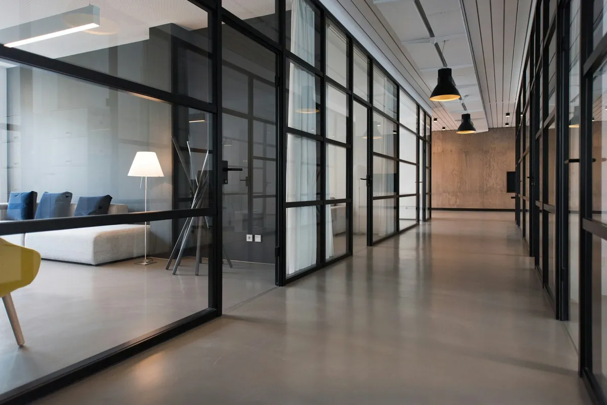 Modern glass-walled consultancy office corridor with warm lighting